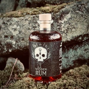Bottle of Fay as Folk Woden Rum standing among moss-covered rocks
