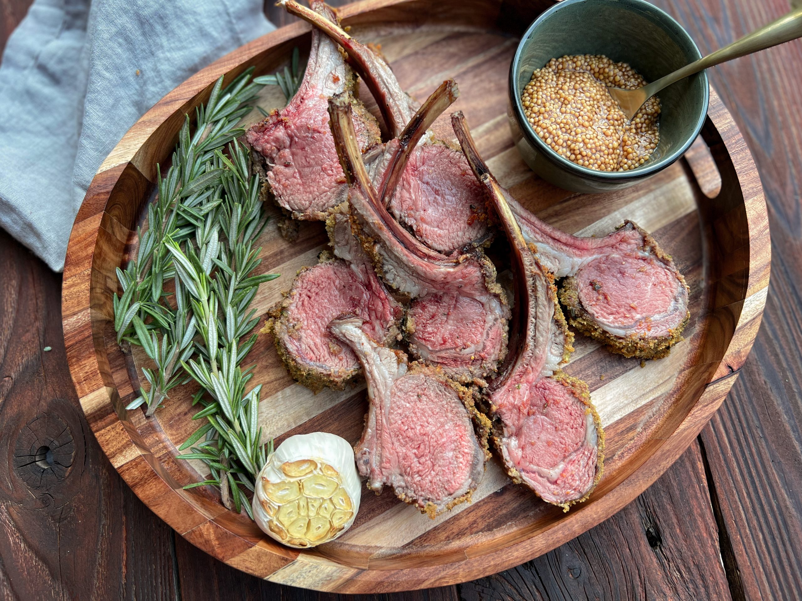 Finished herb crusted lamb served on a wooden board